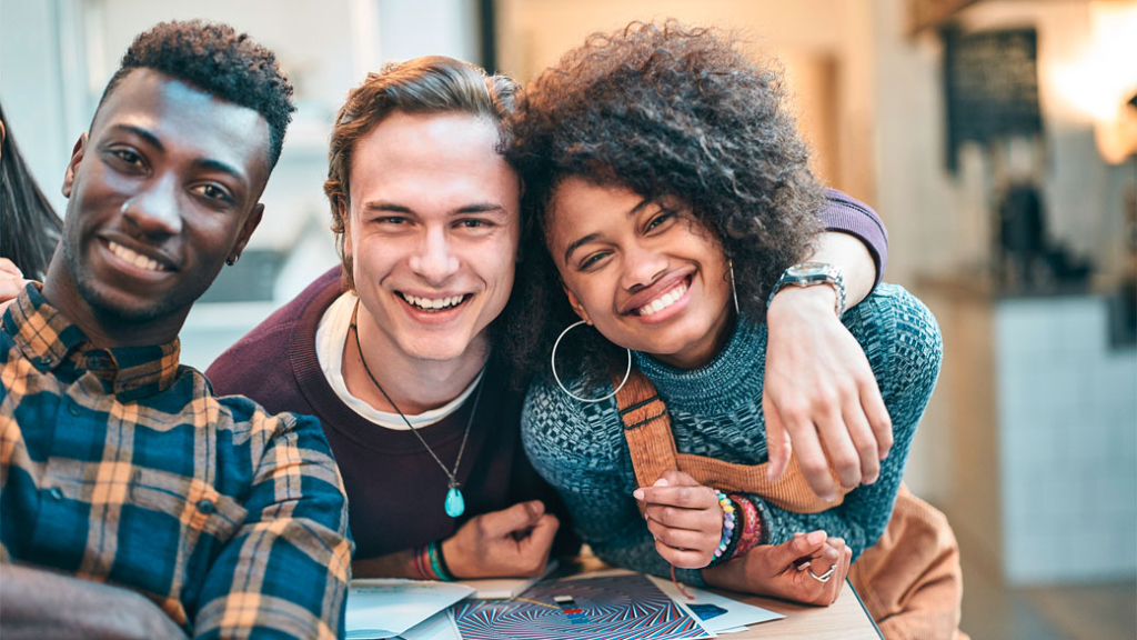 Drei Studenten lächeln in die Kamera. Drei Studenten lächeln in die Kamera.
