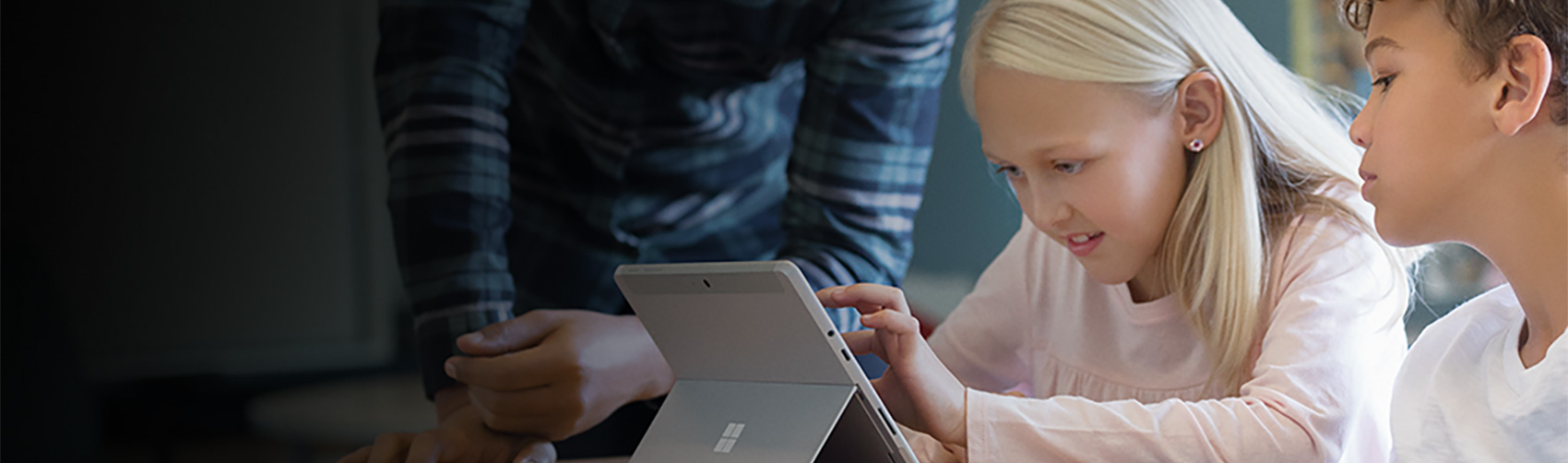 Ein Lehrer hilft einer Schülerin beim Arbeiten an einem Surface laptop