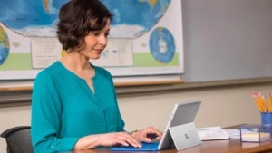 Eine junge Lehrerin bei der Arbeit an einem Laptop im Klassenzimmer