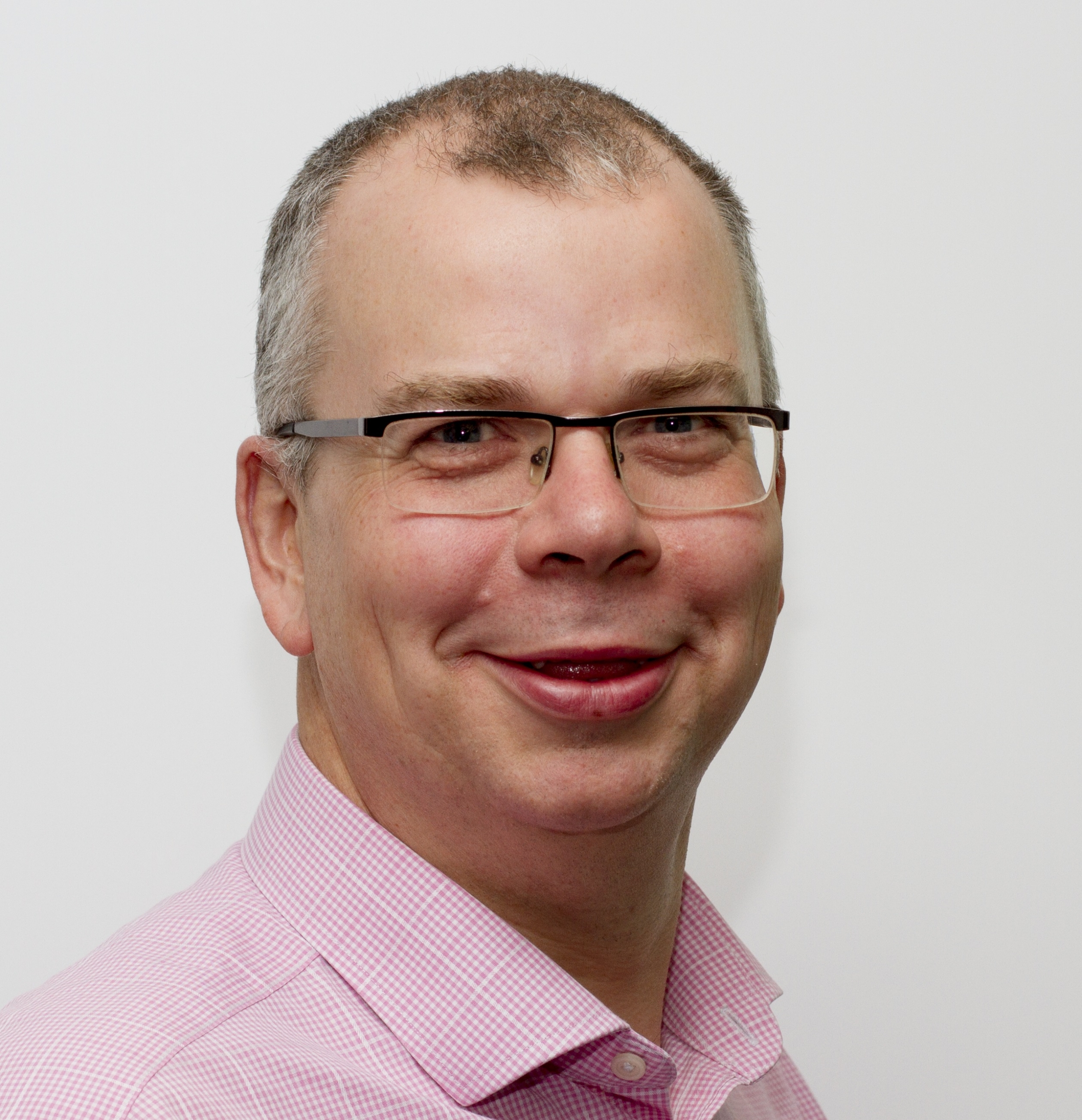 a man wearing glasses and smiling at the camera