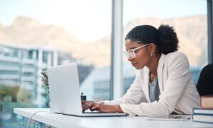 a man and a woman sitting at a table using a laptop