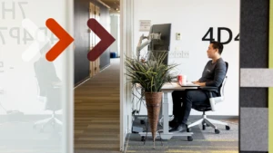 A man sits at a desk and works at a computer.