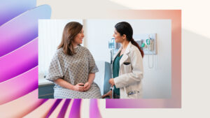 A woman in a hospital gown talking to a doctor