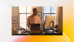 A man in a hoodie looking at a computer