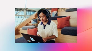 A woman wearing headphones and using a laptop