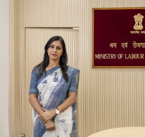 Woman standing in front of a sign reading Ministry of Labour and Employment.