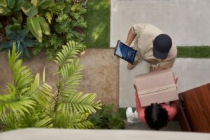 A delivery driver hands a package to a resident at their front door.