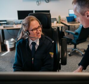 Woman wearing a headset speaks to a man .