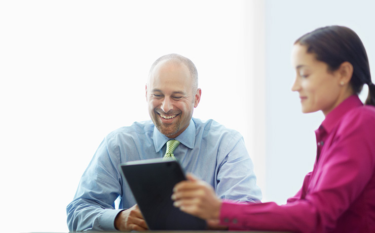 a man and a woman looking at a laptop