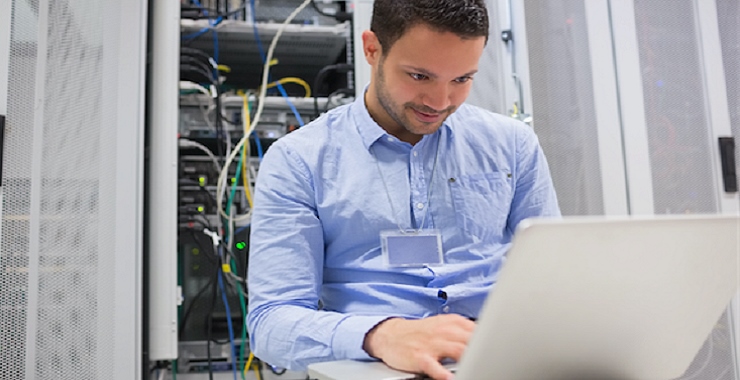 a man sitting in front of a laptop