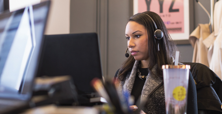 a woman standing in front of a laptop