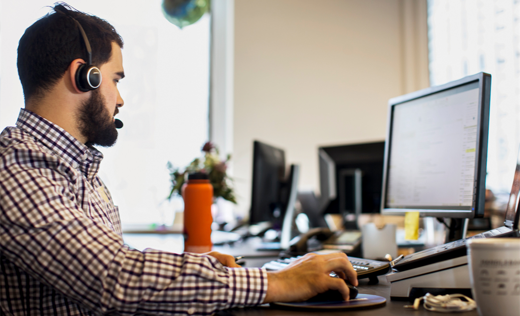 a person sitting at a desk in front of a computer