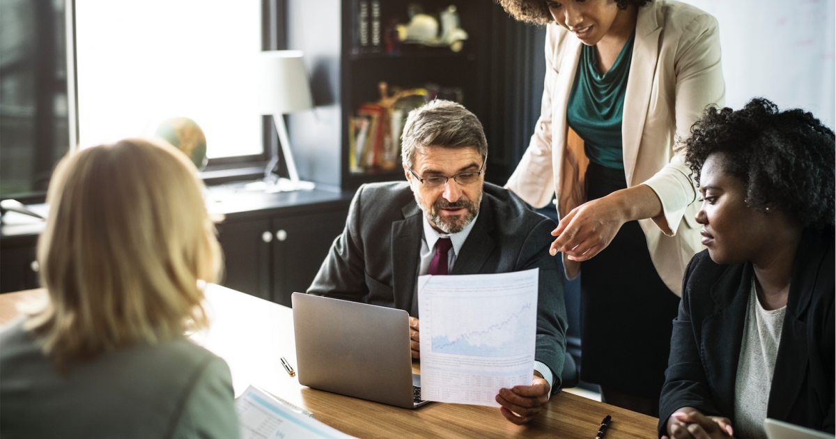 a group of people standing around a table