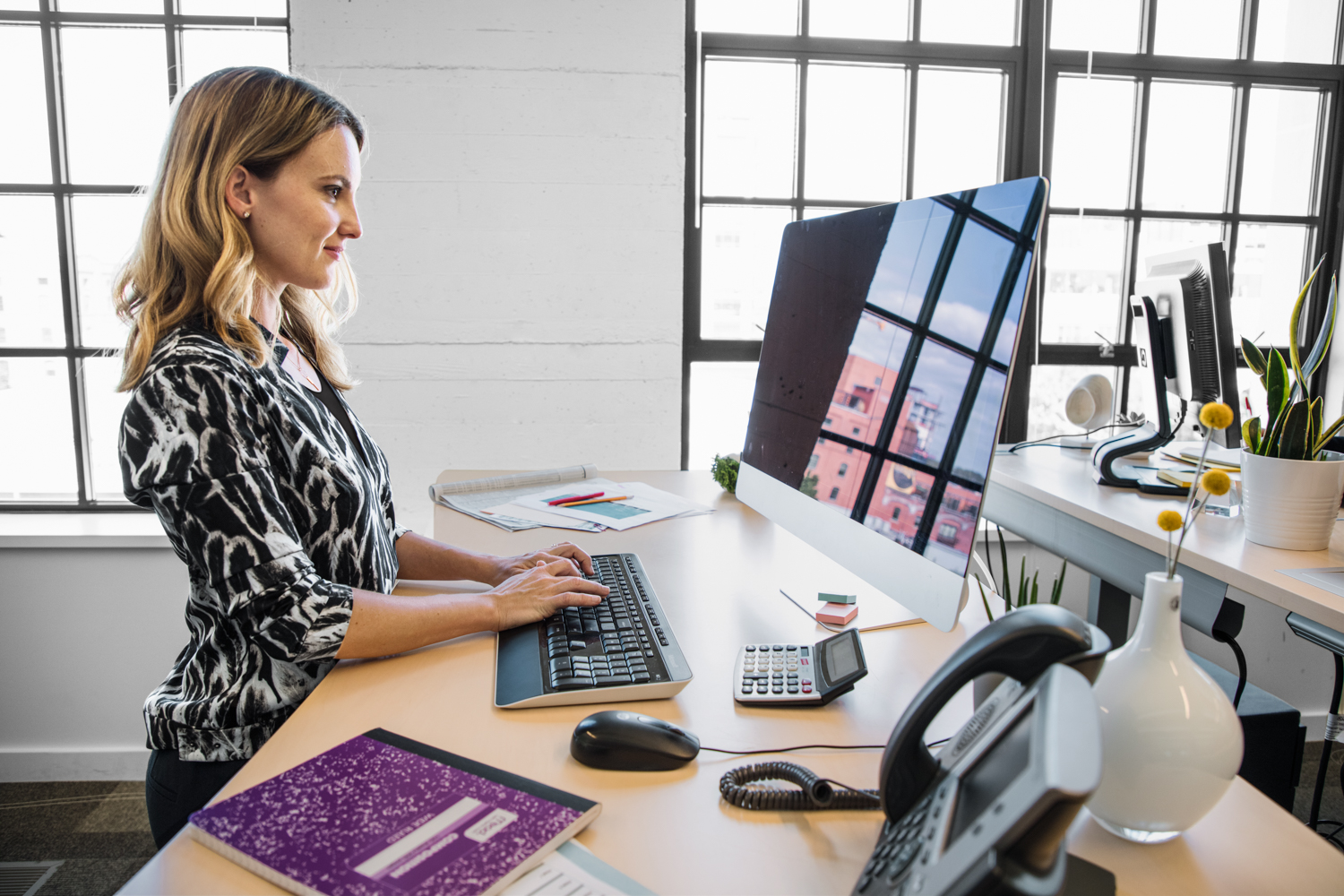 a woman sitting at a table with a laptop