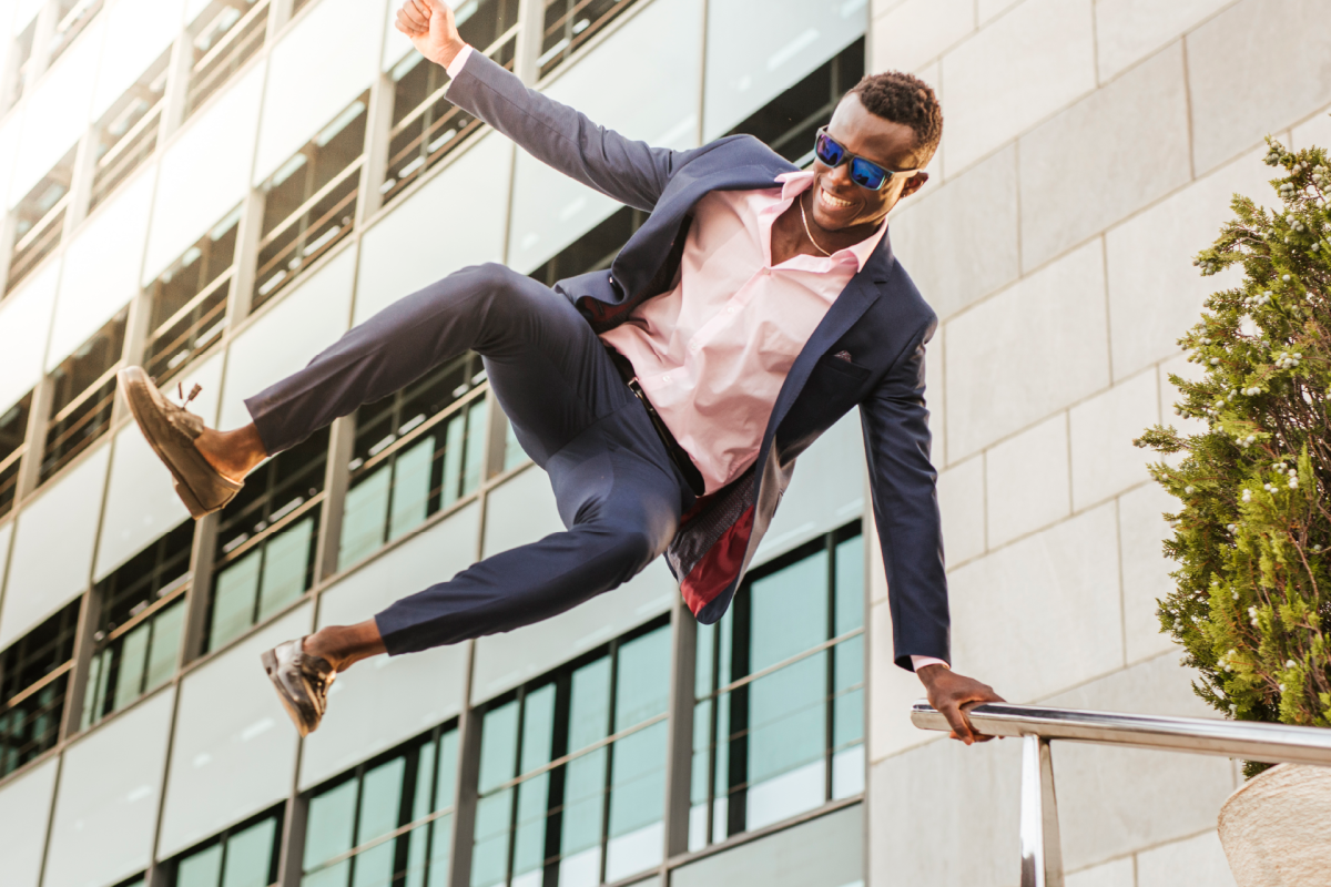 Man jumping and clicking heels in air while smiling