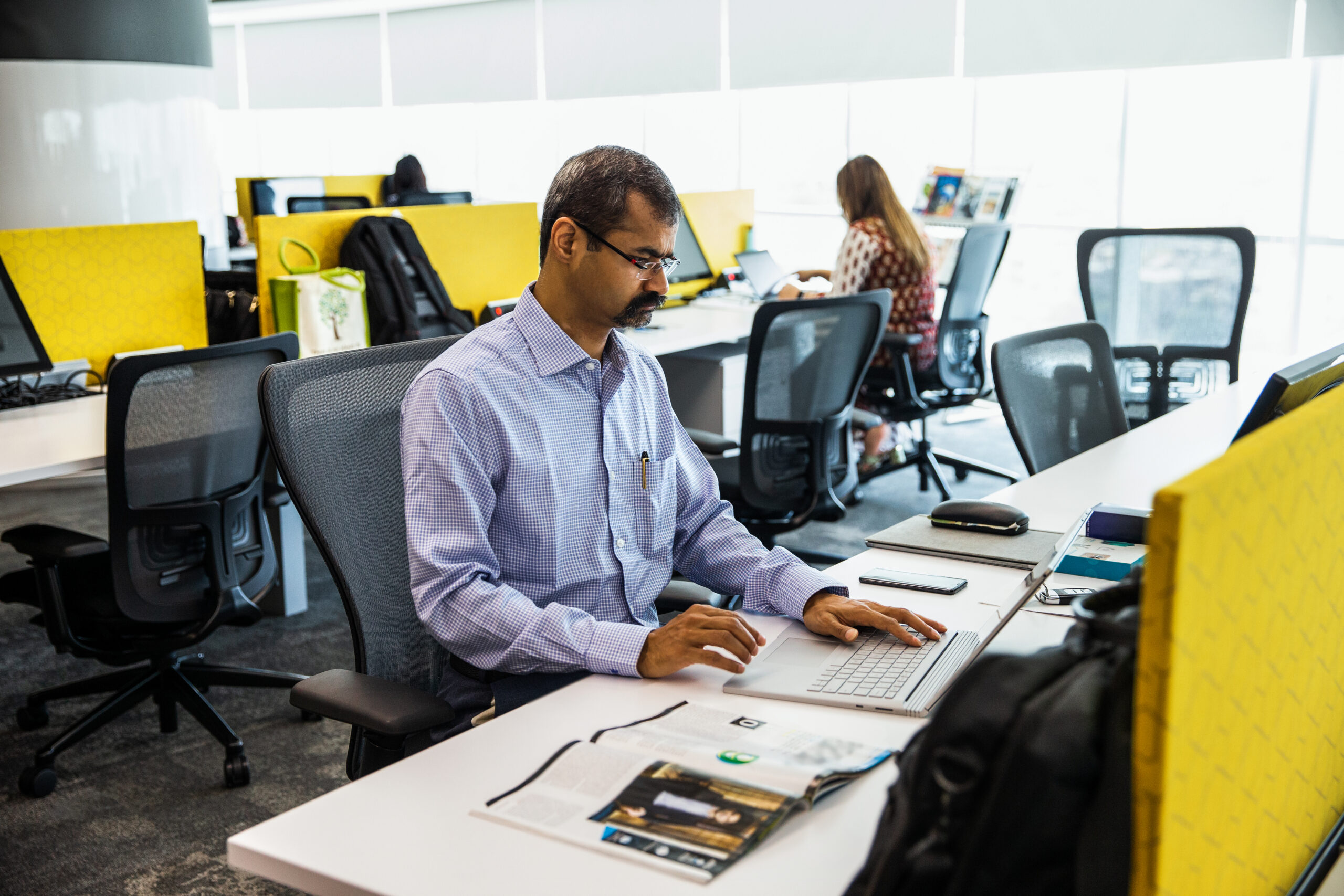 Photo of a man working on a laptop in a contact center.