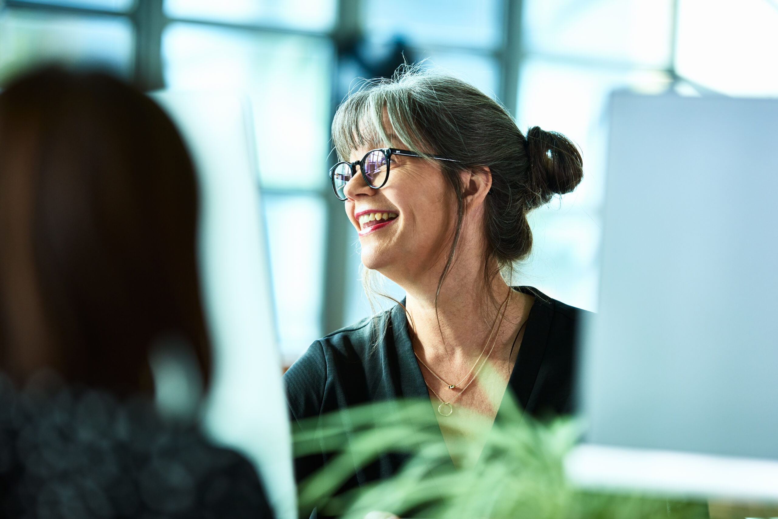 Photo of mature businesswoman in glasses laughing.