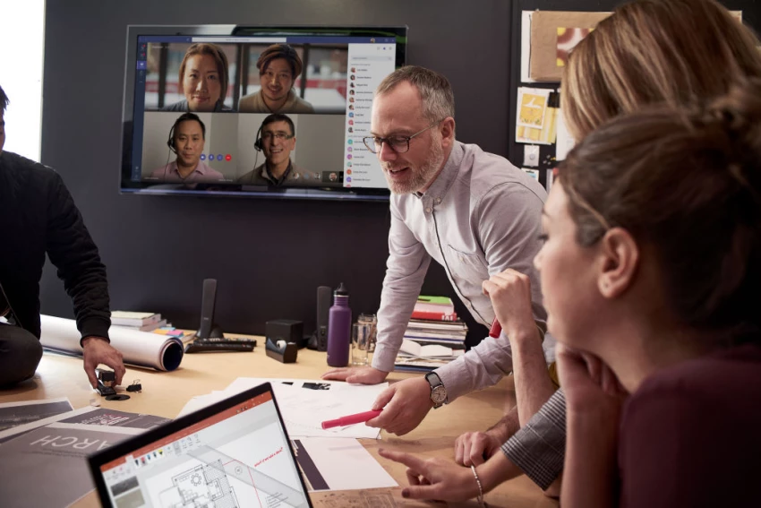 a group of people sitting at a table in front of a computer
