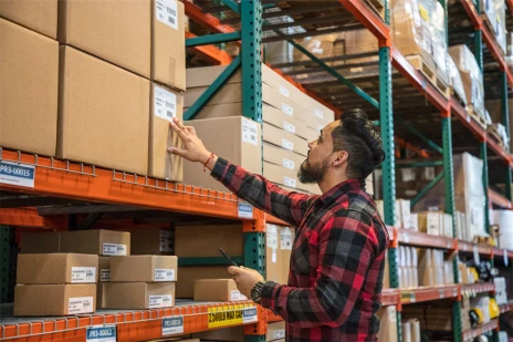a man standing in front of a store Worker scanning items