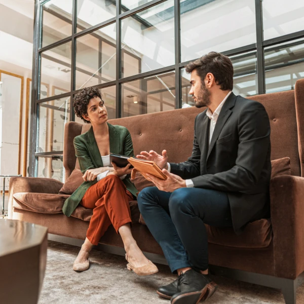 Two salespeople sitting on a couch