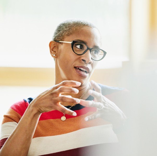 A mature businesswoman in discussion with colleague that is off camera.