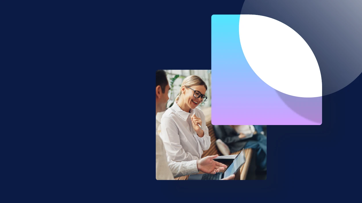 Coworkers sit on a bench in an atrium discussing a new project.