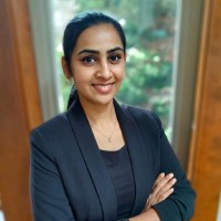 Person standing indoors with arms crossed