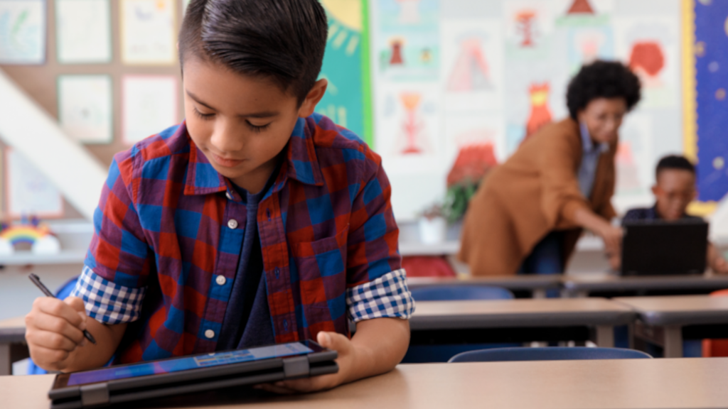Student in a classroom working on a tablet.