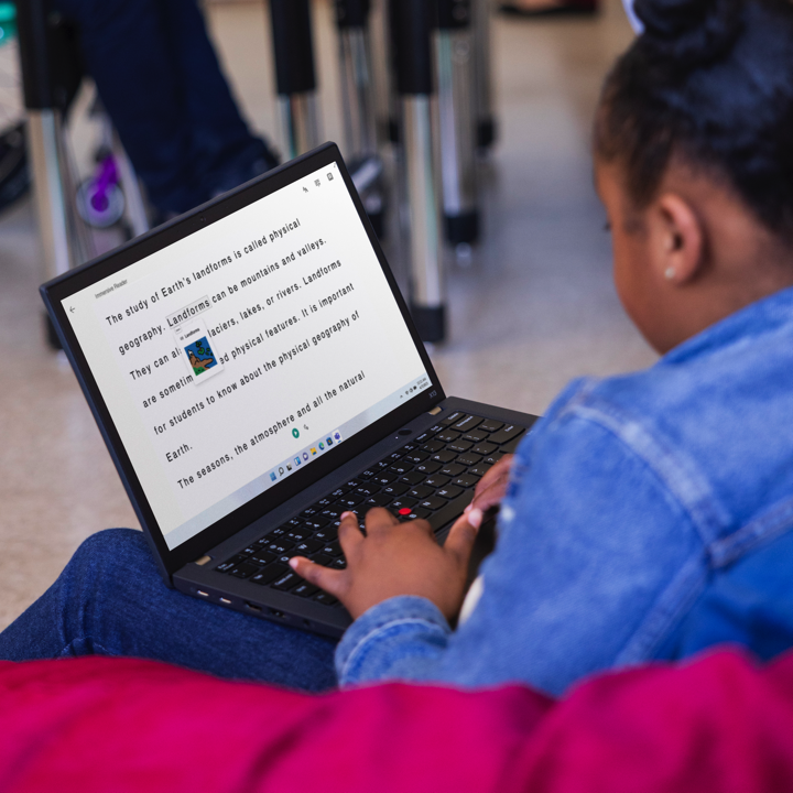 A student using a laptop with Immersive Reader in a classroom.