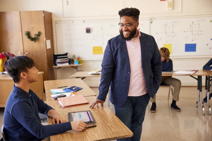An educator engaging with a student in a classroom setting.