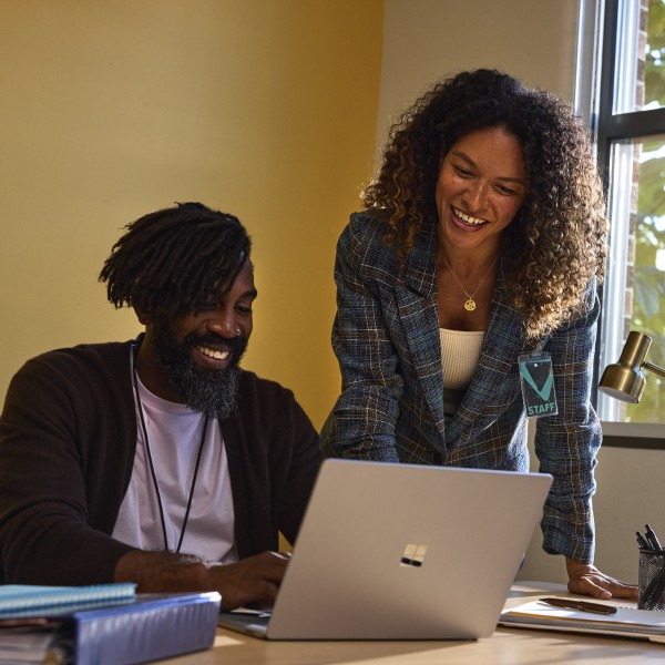 Two education decision makers working together on a laptop in an office.