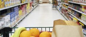 Image of a shopping cart going across an aisle in the supermarket.