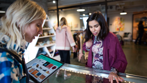 Sales clerk and customer interacting at the counter and using a tablet