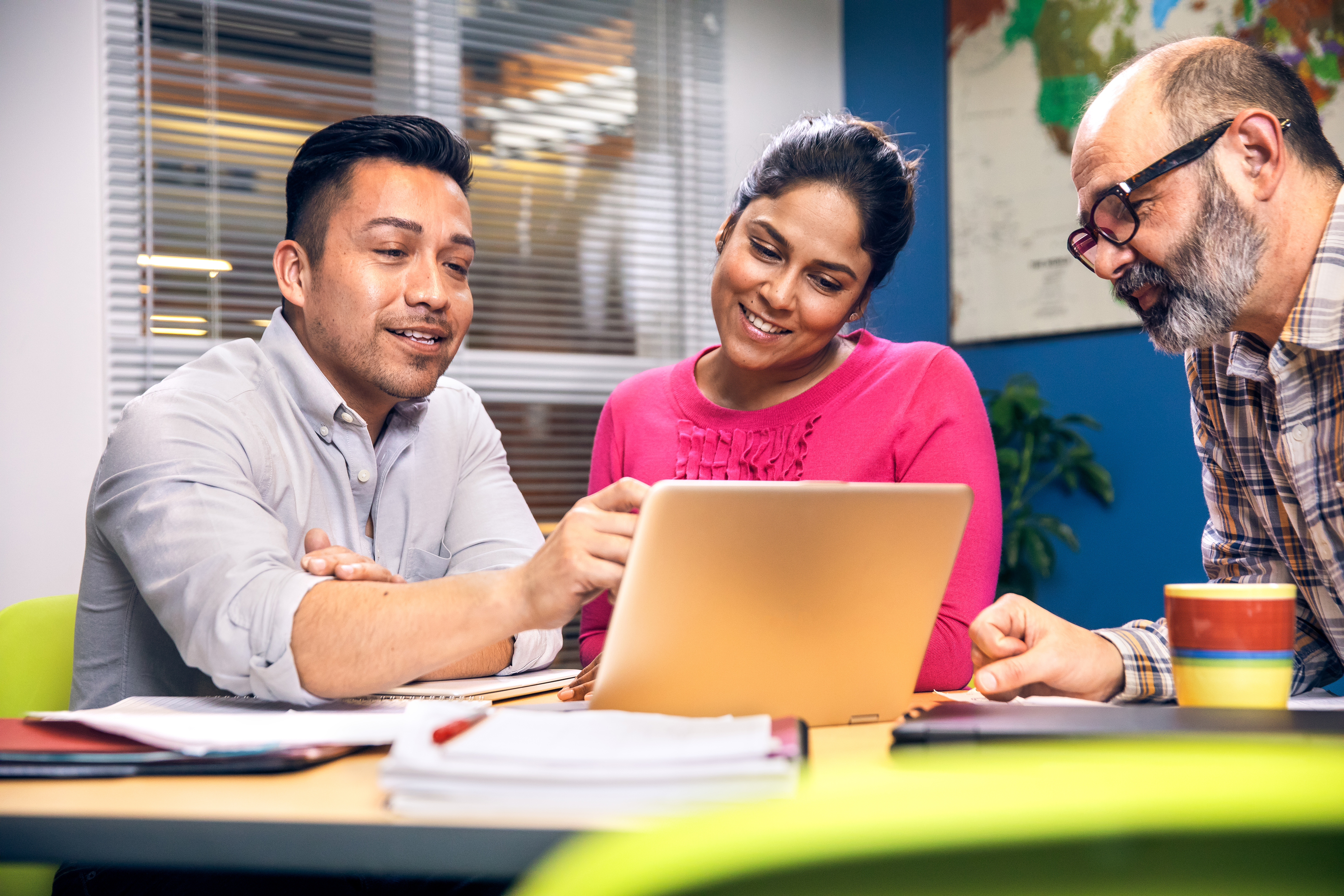 Three people looking at a device