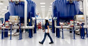 Woman with device walking through plant