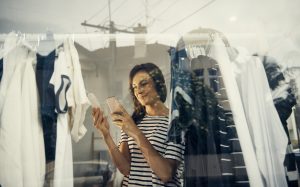 Shopper using a cellphone while looking at a price tag