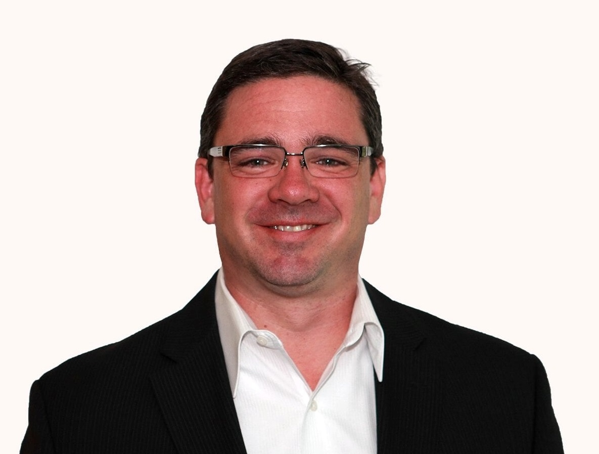 a man wearing a suit and tie smiling at the camera