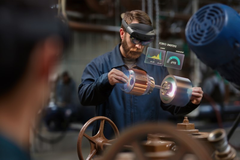 Man in manufacturing plant accessing data via Microsoft Azure. Contains hologram scenario. Contextual imagery.