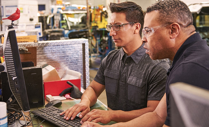 モニターで製造ラインを確認する 2 人の男性