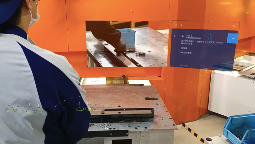 配置された MR 画面のマニュアルを確認しながら作業する男性