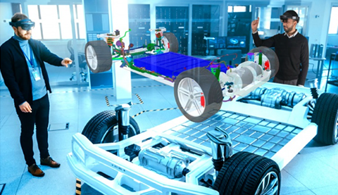 Zwei Männer tragen eine HoloLens Brille und sehen auf ein virtuelles Auto