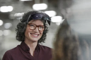 Woman wearing Microsoft Hololens 2 flipped up. Hospitals are using HoloLens 2 for remote assist in patient care