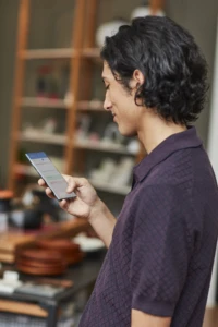 A man contacting his bank on his phone. Digitalisation offers omni-channel experiences.