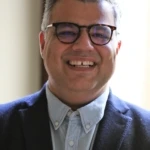 Ali Rezvan, a man wearing glasses and a suit and tie