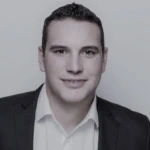 Dan Cousineau, a man in business suit smiling at the camera.