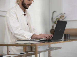 Adult male inside working from home on Surface laptop 3. Hybrid working can increase insider risk.
