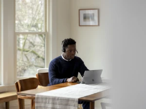 Adult male inside using Microsoft Modern USB Headset and Surface Pro accessing his work with the cloud