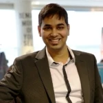 Prajakt Deotale, a man wearing a suit smiling at the camera