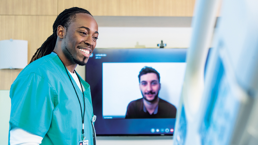 Nurse smiling at a man in Microsoft Teams video call.