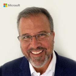 a man wearing a suit and tie smiling at the camera